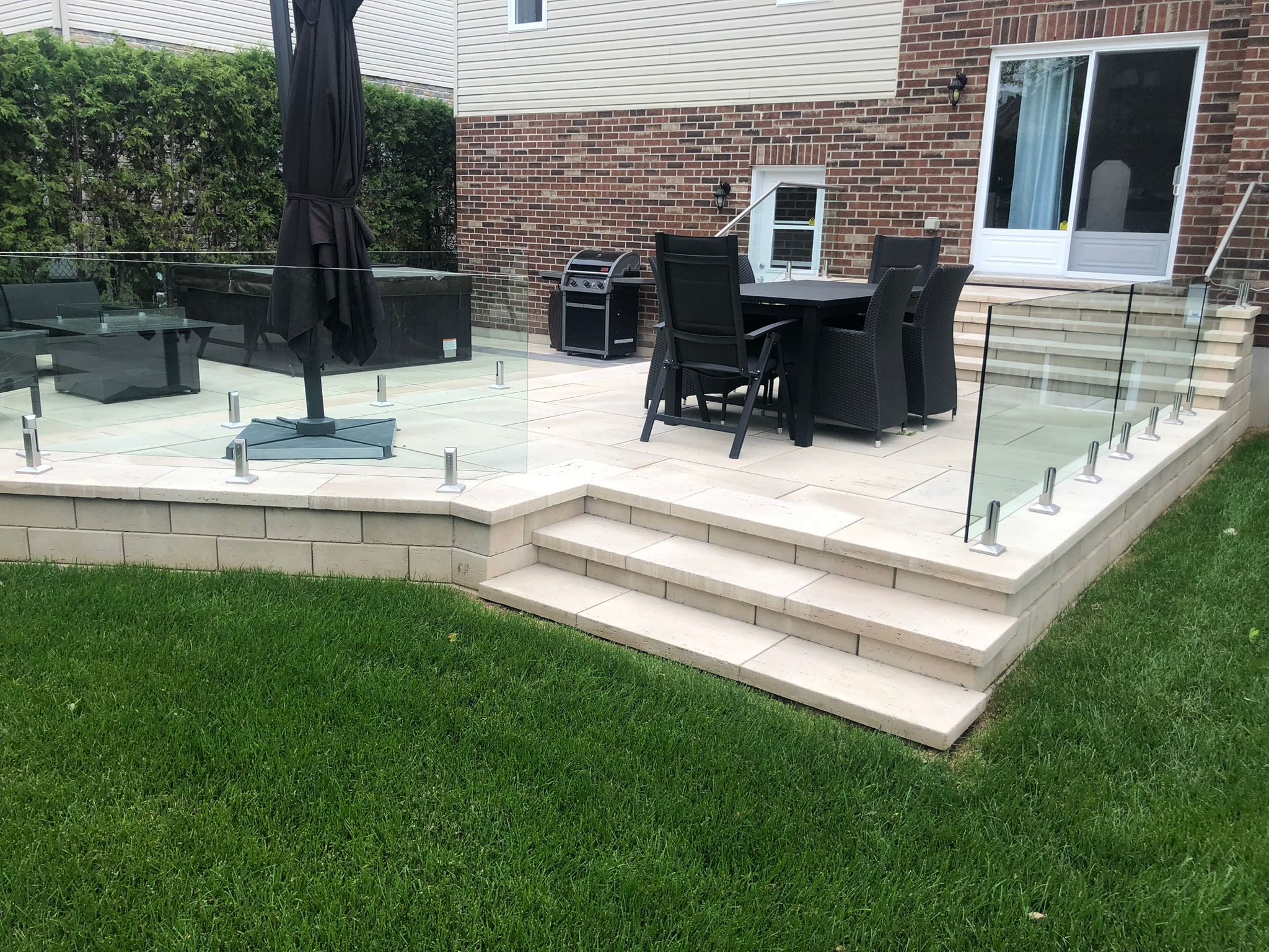 Raised backyard terrace with glass railing